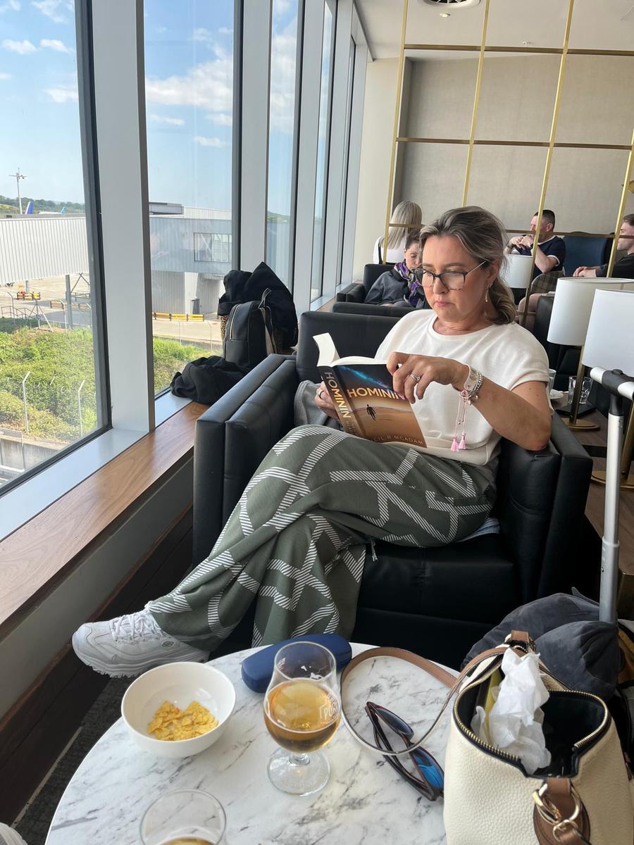 Person holding the book Hominin by Neil R McAdam