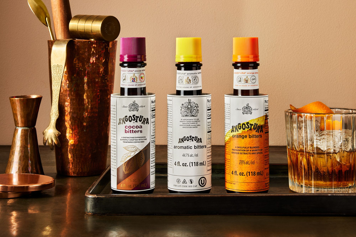A selection of Angostura Bitters bottles displayed with cocktail making paraphernalia
