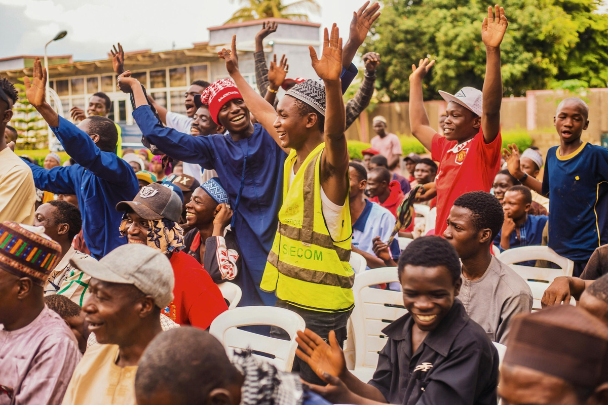 Crowd of people clapping and waving their hands