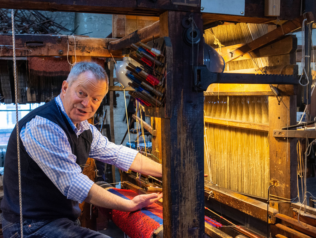 Retired policeman and now museum volunteer Tim Lightfoot grapples with the challenges of using a hand loom in the Paradise Mill