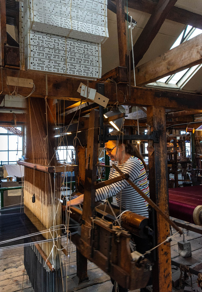 Trish Halloran demonstrates the use of a Jacquard hand loom in Paradise Mill, showing the &lsquo;chain&rsquo; of punched cards that control the pattern