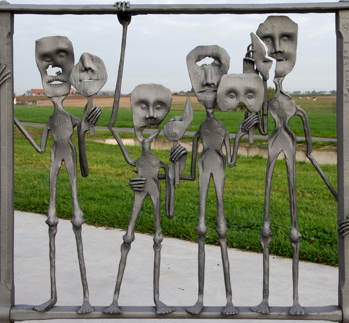 <p>Sculptures at the Ypres Peace Monument located next to the German Cemetery at Langemark. These broken and torn figures are among a series set into the railings around the memorial created by international craftsmen to illustrate their interpretations on war and remembrance.</p>