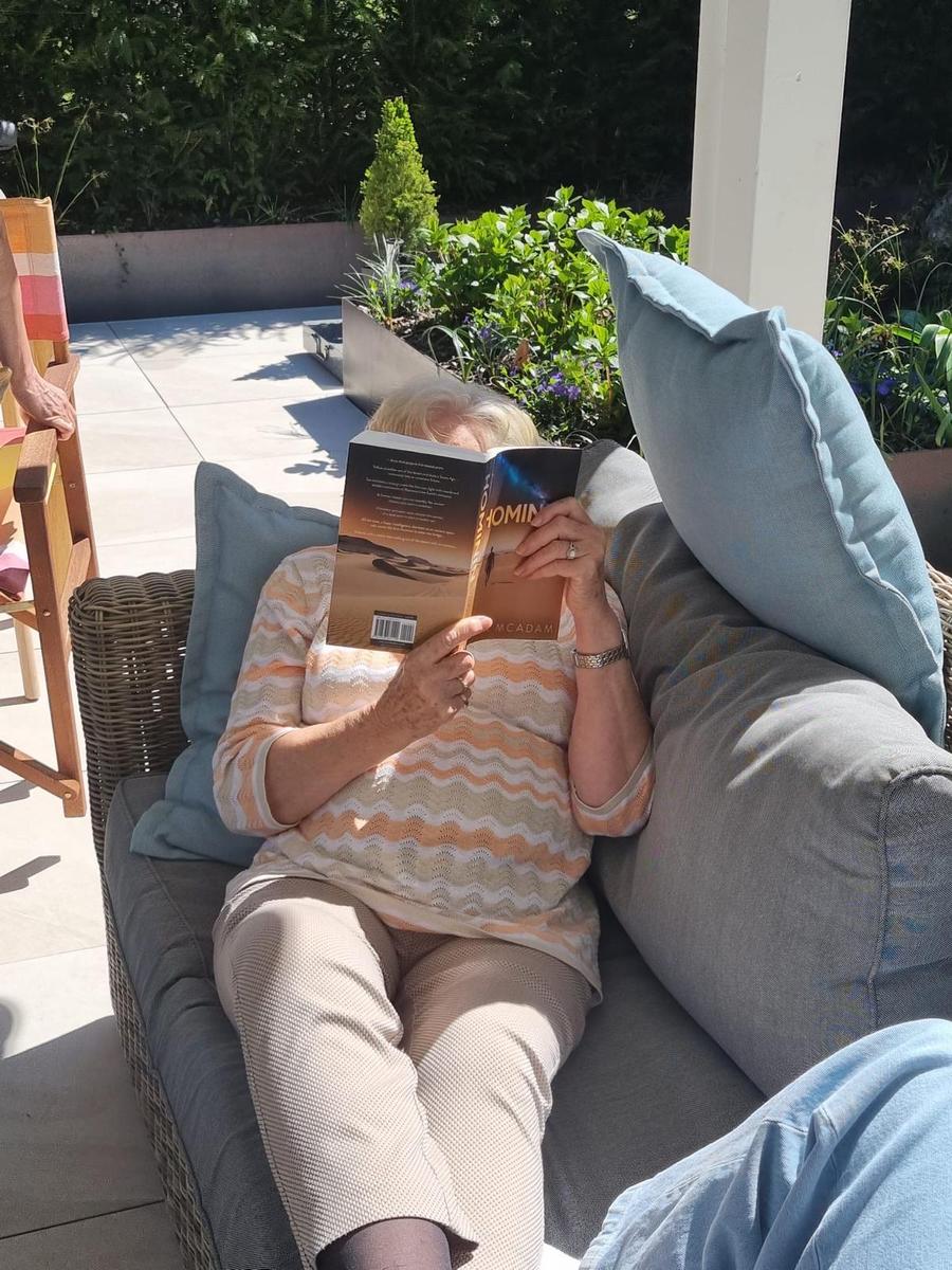 Person holding the book Hominin by Neil R McAdam
