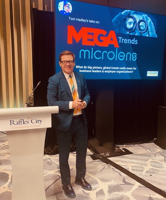 Tom Hadley beside his Mega-Trends, Micro-Lens title slide