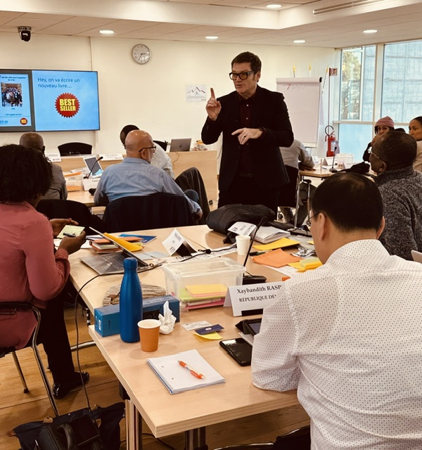 Tom Hadley leading a training session around a boardroom table