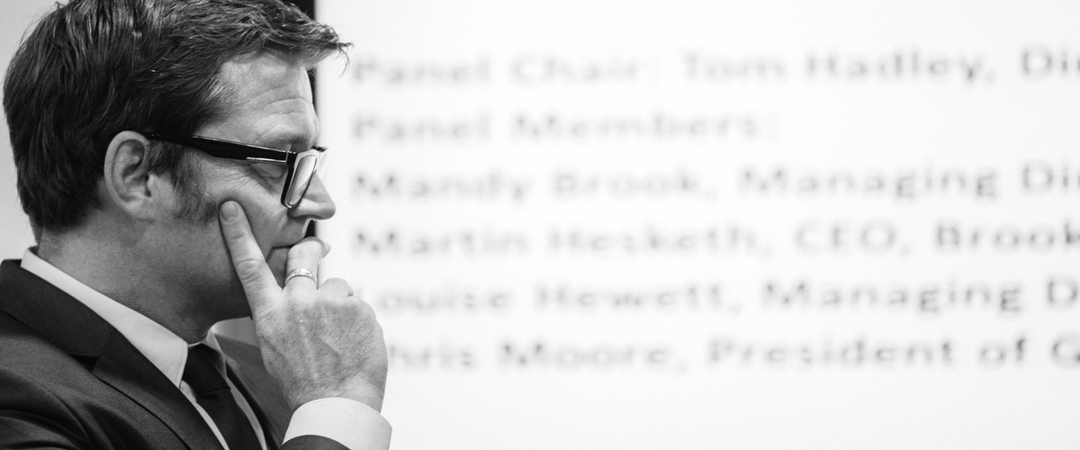 Black-and-white profile of Tom Hadley listening during an event