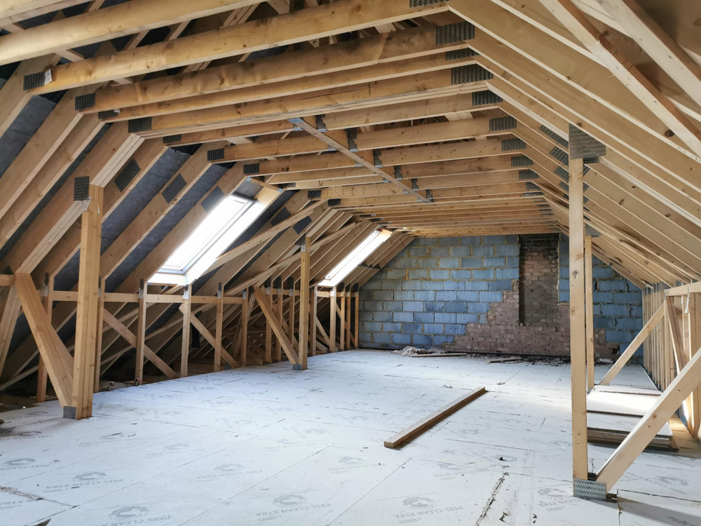 Loft conversion in progress with new roof timbers, roof windows and flooring