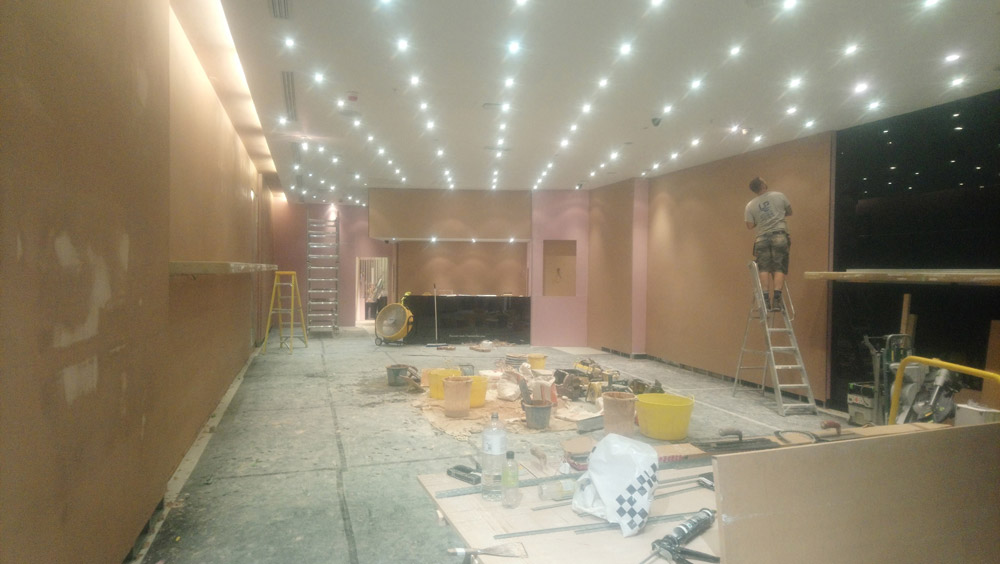Commercial unit fit-out with ceiling downlights and boarded walls
