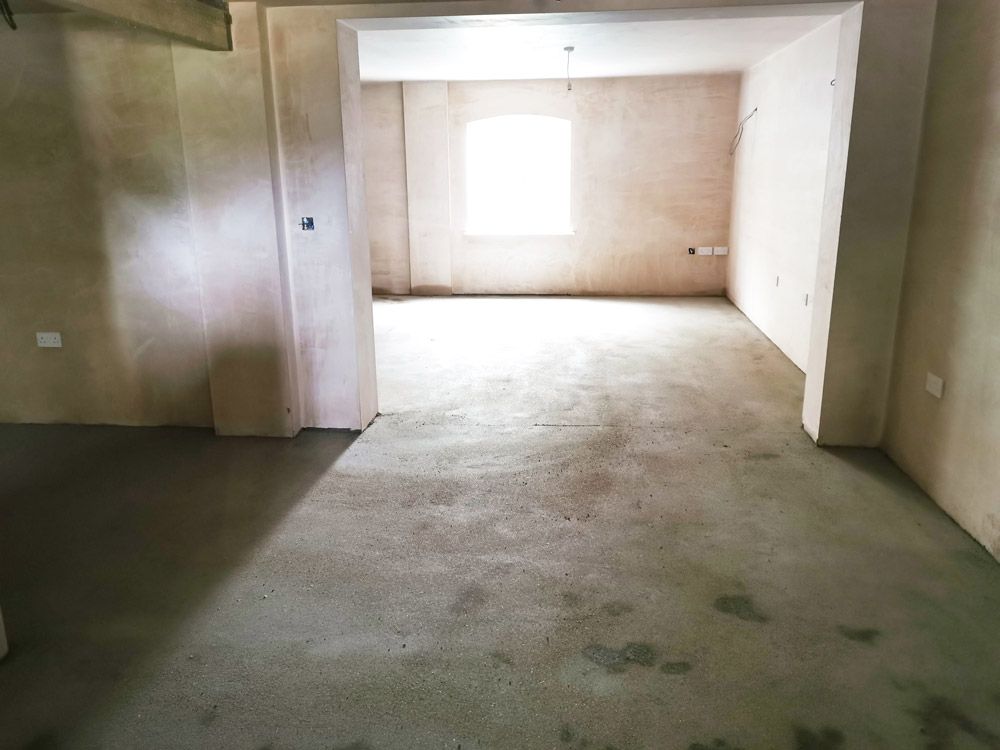 Plastered open-plan room ready for flooring during a renovation