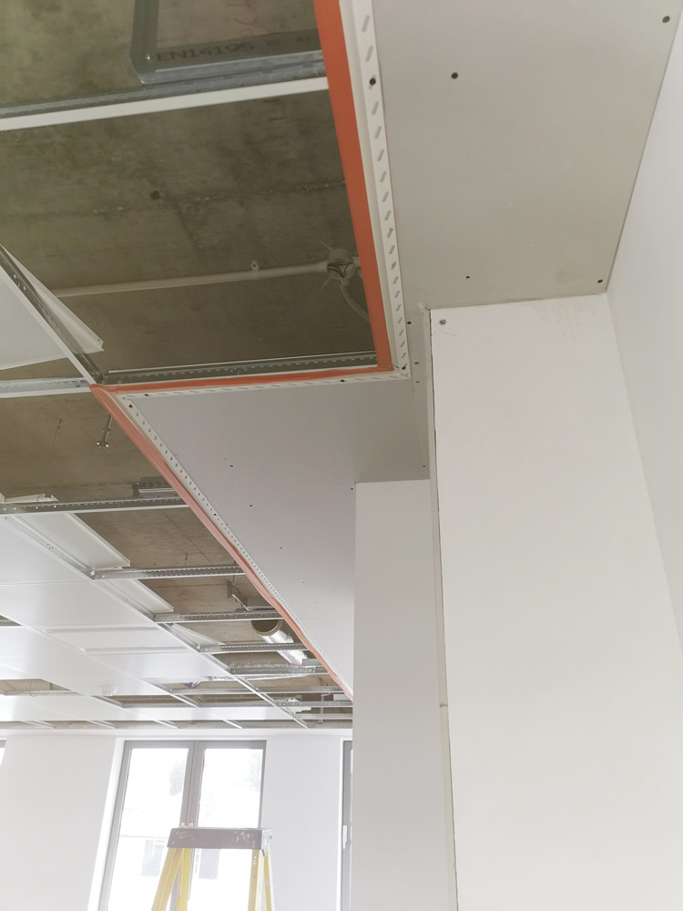 Plasterboard ceiling and walls being installed during an interior refurbishment