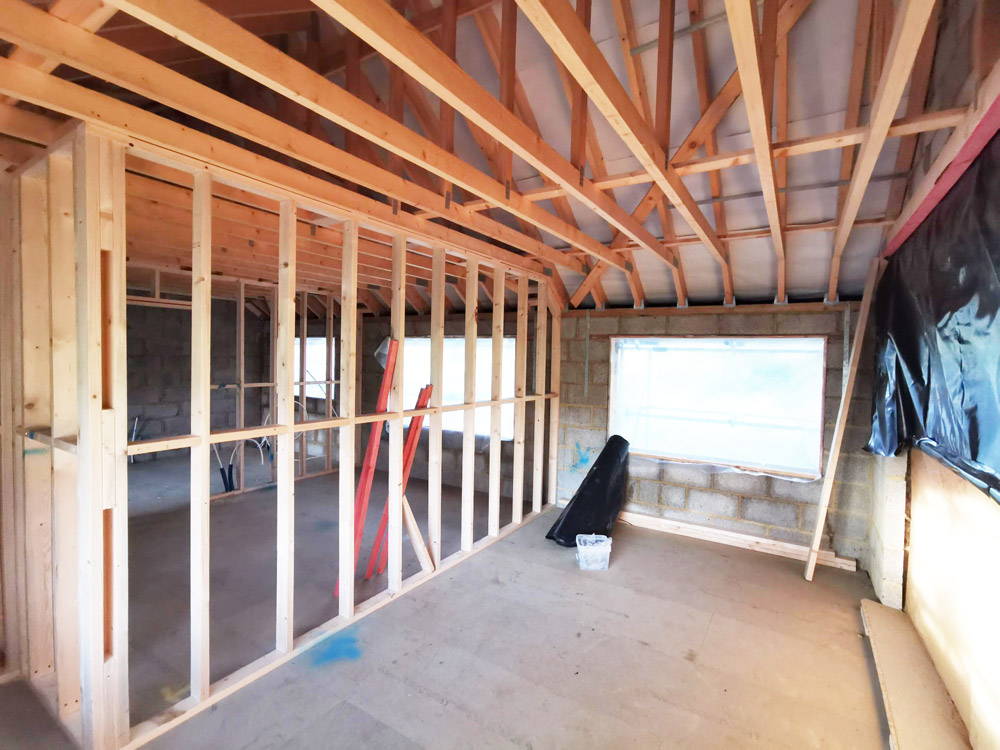 Timber stud walls and roof joists framing a new extension interior