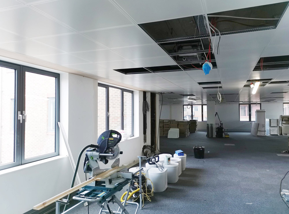 Office refurbishment in progress with a mitre saw and open ceiling