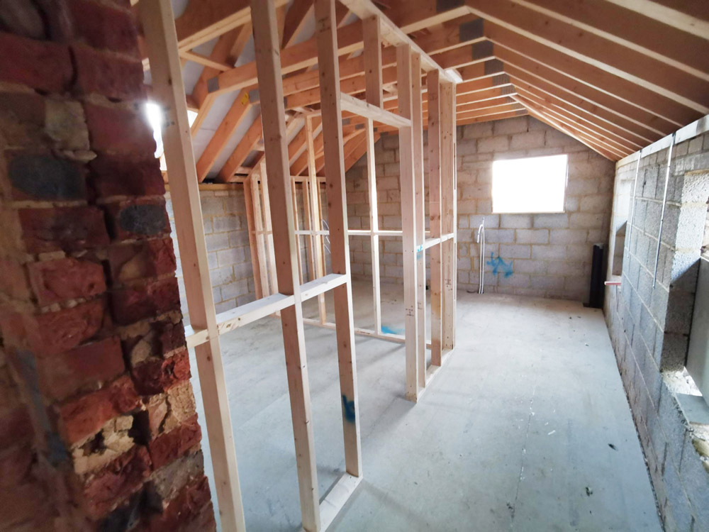 Timber stud walls inside a blockwork extension with exposed roof timbers