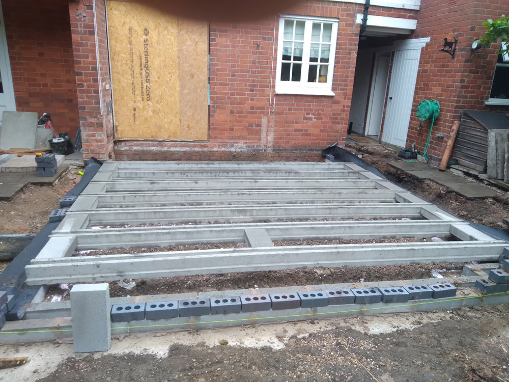 Beam-and-block floor laid for a rear extension beside a red brick house