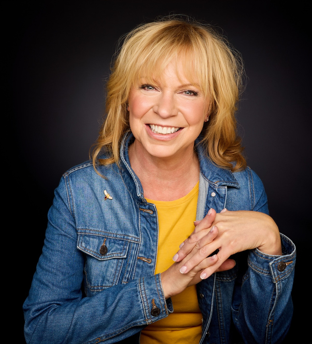 Paula Ketterer smiling against a dark background