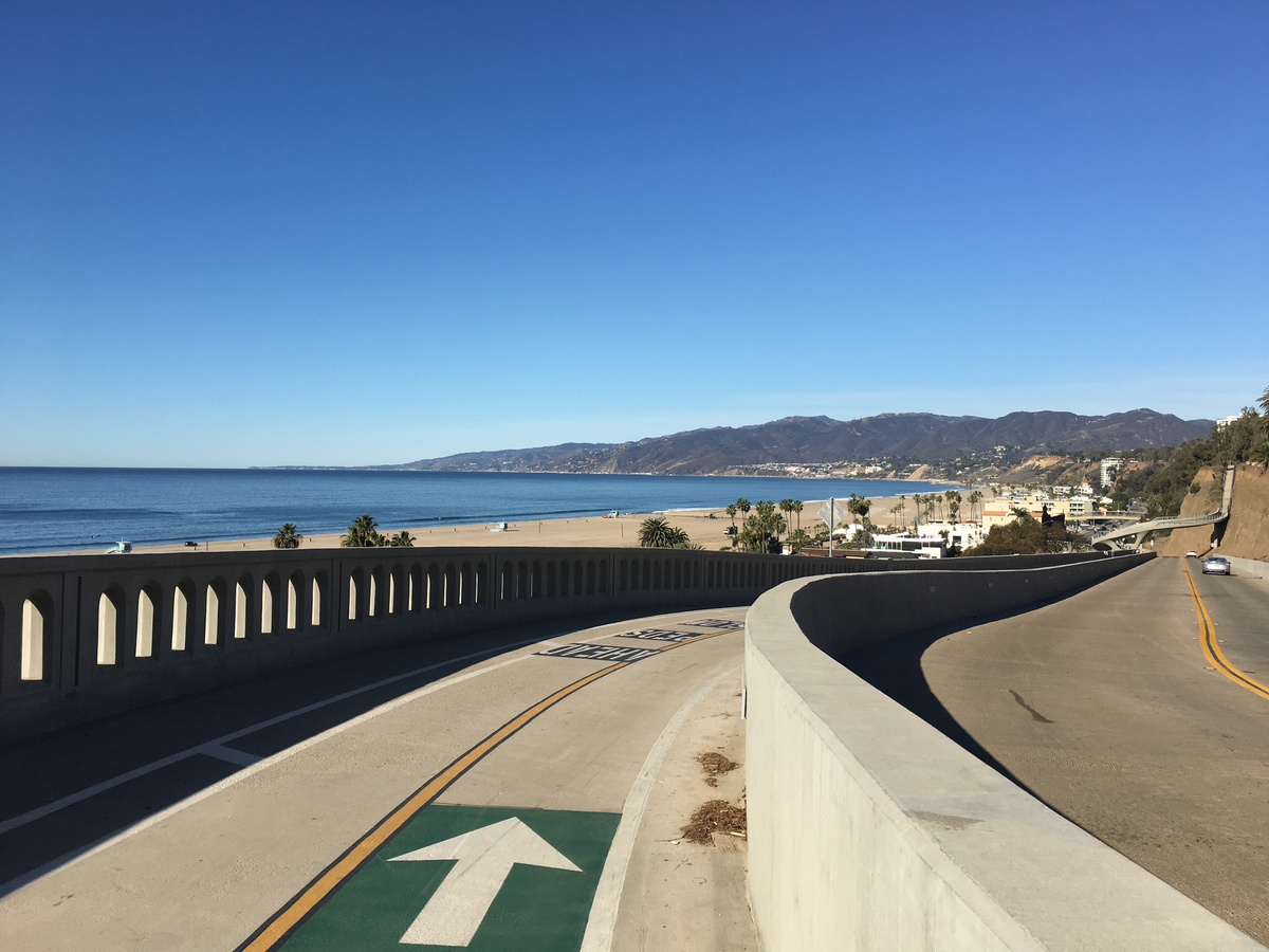 A curving coastal road overlooking Santa Monica Beach