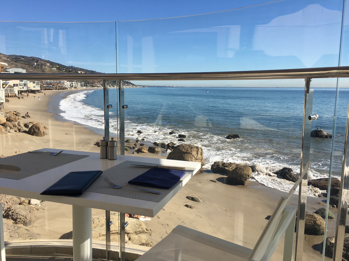 An oceanfront table overlooking a rocky Malibu beach