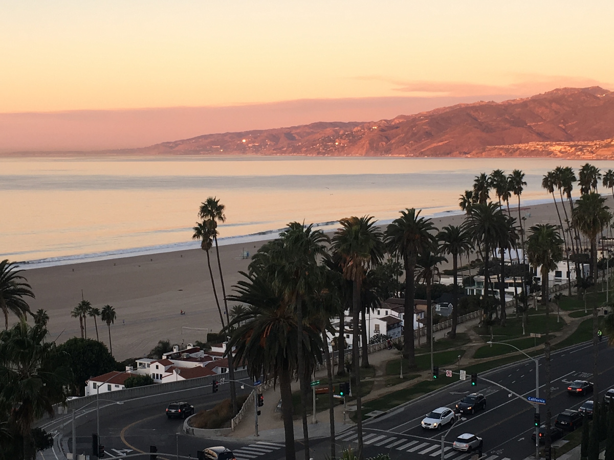 Sunset over Santa Monica Beach and its palm-lined coastline