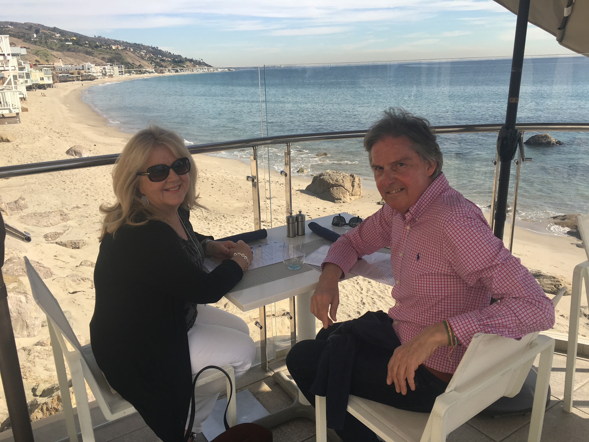 Carole Ryder and a companion at an oceanfront table in Malibu