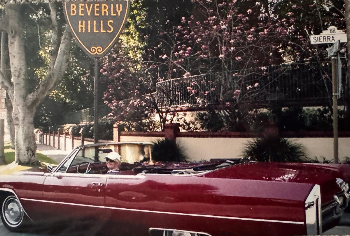 Carole Ryder driving a red vintage convertible in Beverly Hills
