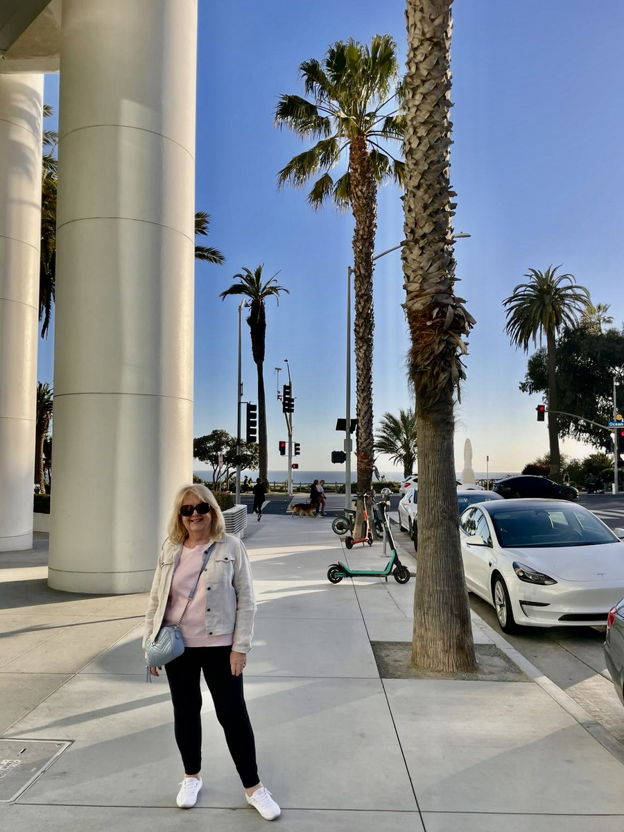 Carole Ryder standing on a palm-lined street in Los Angeles