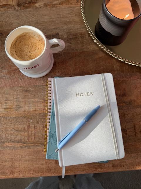 Notepad and cup of coffee on a wooden table