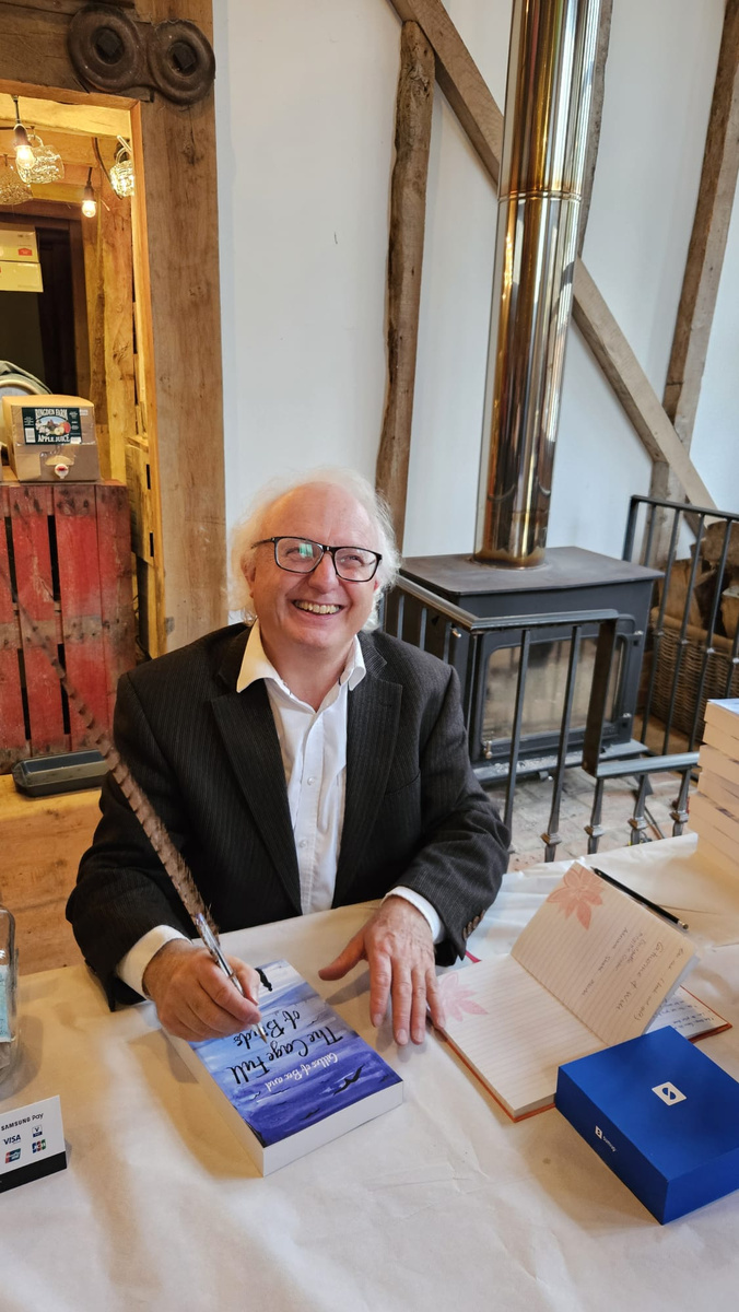 T D Owen signing a copy of The Cage Full of Birds